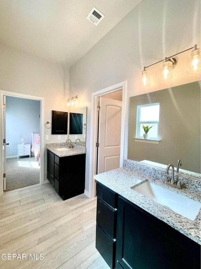 3897 Surmise St, El Paso, TX 79938 - bathroom with two vanities, wood finished floors, vaulted ceiling, and ensuite bathroom