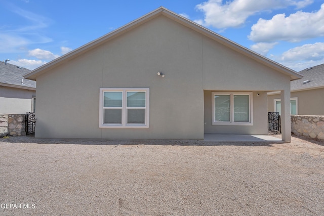 rear view of property with a patio and stucco siding