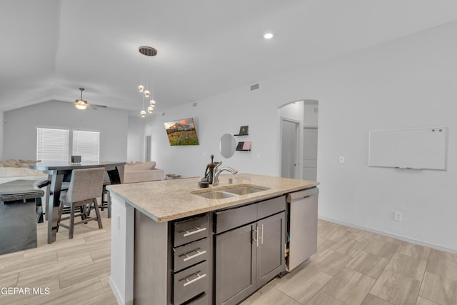 kitchen featuring arched walkways, dishwasher, a sink, open floor plan, and a ceiling fan
