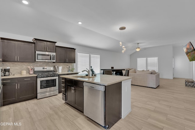 kitchen with a sink, ceiling fan, dark brown cabinets, vaulted ceiling, and stainless steel appliances