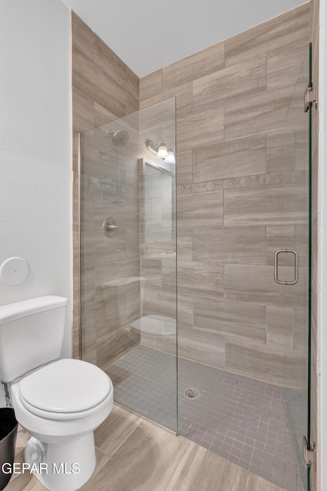 full bath with a shower stall and toilet