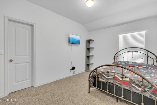 carpeted bedroom with baseboards and lofted ceiling
