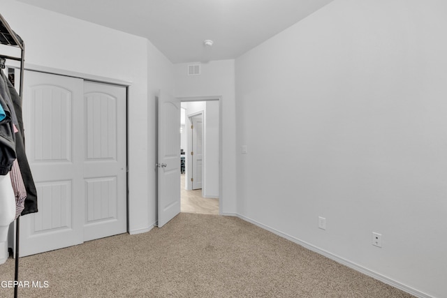 unfurnished bedroom with visible vents, baseboards, a closet, and carpet
