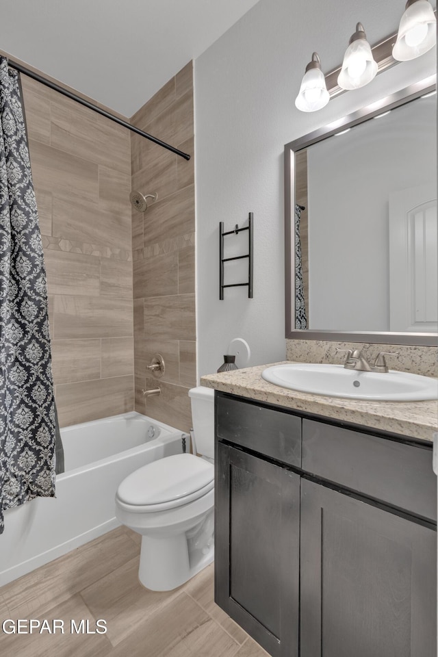 bathroom featuring vanity, shower / bath combination with curtain, and toilet