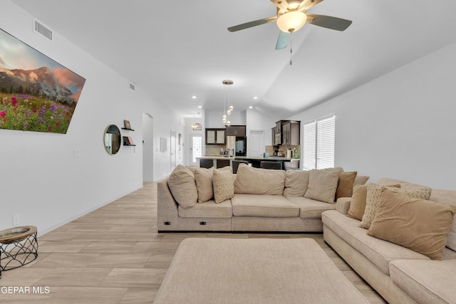 living area with ceiling fan, arched walkways, visible vents, recessed lighting, and lofted ceiling