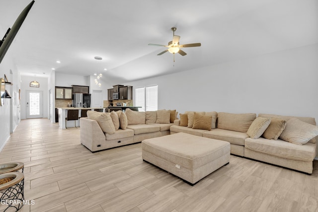 living room with a ceiling fan and vaulted ceiling