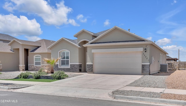 view of front of property featuring stone siding, a garage, cooling unit, stucco siding, and driveway