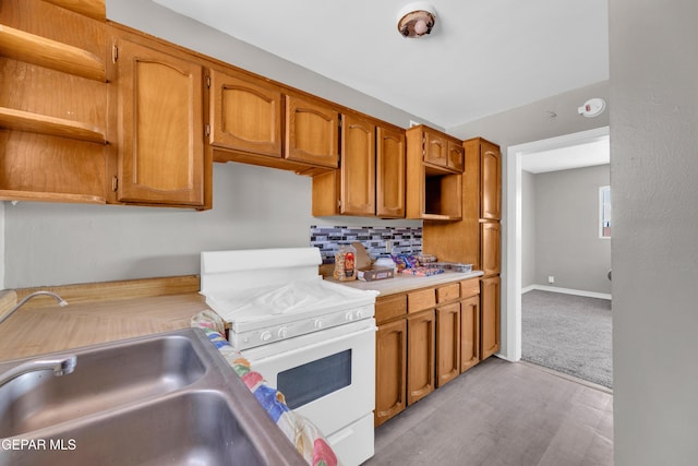 2413 Copper Ave Unit 79930, El Paso, TX 79930 - kitchen with white gas range oven, open shelves, light countertops, tasteful backsplash, and brown cabinetry