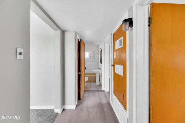 2413 Copper Ave Unit 79930, El Paso, TX 79930 - corridor with wood finished floors, baseboards, and a textured ceiling