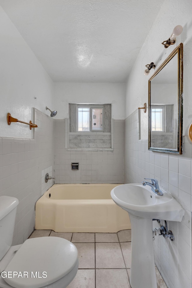2413 Copper Ave Unit 79930, El Paso, TX 79930 - full bathroom featuring tile walls, toilet, tile patterned floors, tub / shower combination, and a wainscoted wall
