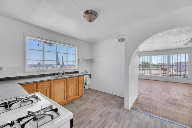 2413 Copper Ave Unit 79930, El Paso, TX 79930 - kitchen featuring arched walkways, white range with gas stovetop, plenty of natural light, and dark countertops