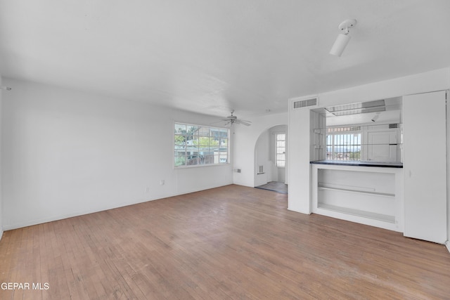 2413 Copper Ave Unit 79930, El Paso, TX 79930 - unfurnished living room featuring arched walkways, ceiling fan, hardwood / wood-style flooring, and baseboards