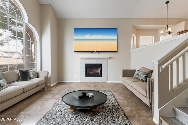 10892 Reef Sands Dr, El Paso, TX 79924 - tiled living room featuring a tile fireplace, baseboards, stairs, and a wealth of natural light