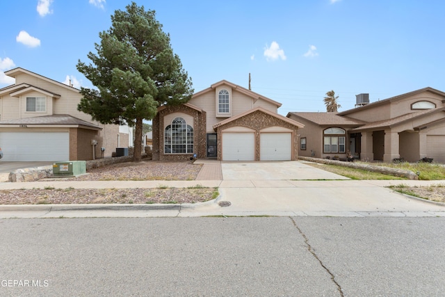 10892 Reef Sands Dr, El Paso, TX 79924 - view of front of property with cooling unit, brick siding, driveway, and an attached garage