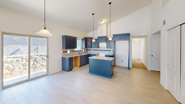 14764 Jack White Ave, El Paso, TX 79938 - kitchen featuring high vaulted ceiling, light countertops, a kitchen island, pendant lighting, and decorative backsplash
