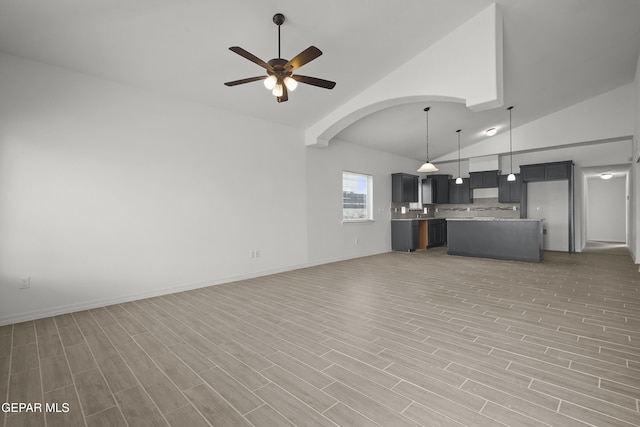 2217 Tony Harper St, El Paso, TX 79938 - unfurnished living room featuring a ceiling fan, high vaulted ceiling, light wood-style flooring, and arched walkways