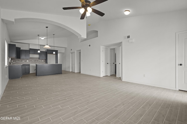 2217 Tony Harper St, El Paso, TX 79938 - unfurnished living room featuring ceiling fan, high vaulted ceiling, and light wood-style floors