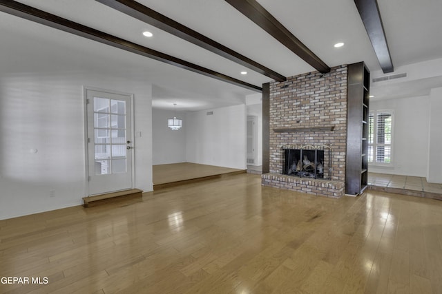 4945 Vista Grande Cir, El Paso, TX 79922 - unfurnished living room with baseboards, beamed ceiling, light wood-style flooring, and a brick fireplace