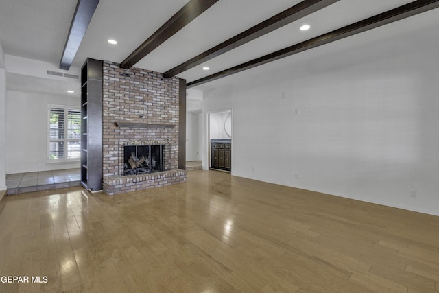 4945 Vista Grande Cir, El Paso, TX 79922 - unfurnished living room featuring visible vents, a fireplace, wood finished floors, and beamed ceiling