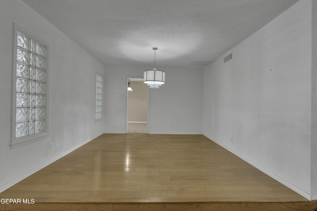 4945 Vista Grande Cir, El Paso, TX 79922 - unfurnished dining area with an inviting chandelier, wood finished floors, plenty of natural light, and visible vents