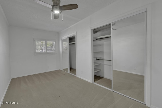 4945 Vista Grande Cir, El Paso, TX 79922 - unfurnished bedroom featuring multiple closets, a textured ceiling, baseboards, ornamental molding, and carpet floors