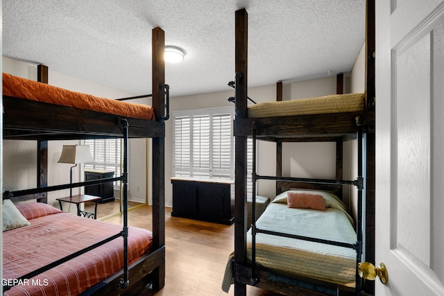 bedroom featuring a textured ceiling and wood finished floors
