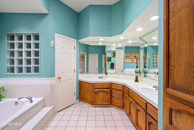 full bath with a bath, tile patterned floors, double vanity, and a sink
