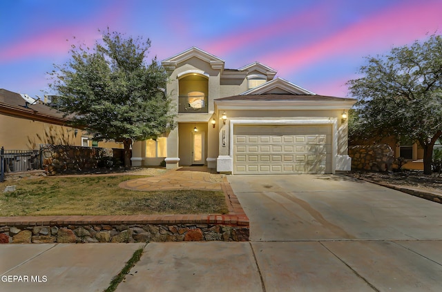 view of front of property featuring a garage, driveway, stucco siding, and fence