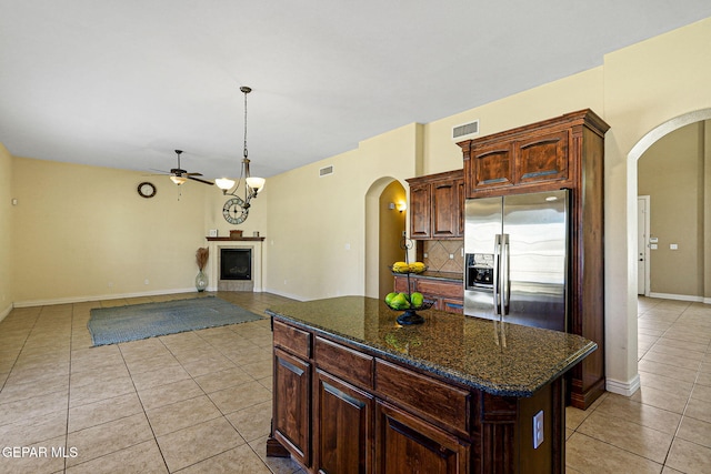 kitchen with visible vents, stainless steel fridge, ceiling fan, tasteful backsplash, and arched walkways