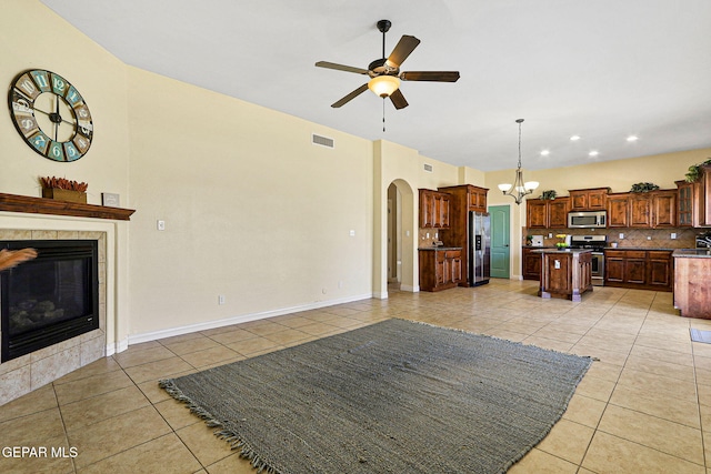 kitchen featuring light tile patterned flooring, visible vents, stainless steel appliances, and ceiling fan with notable chandelier