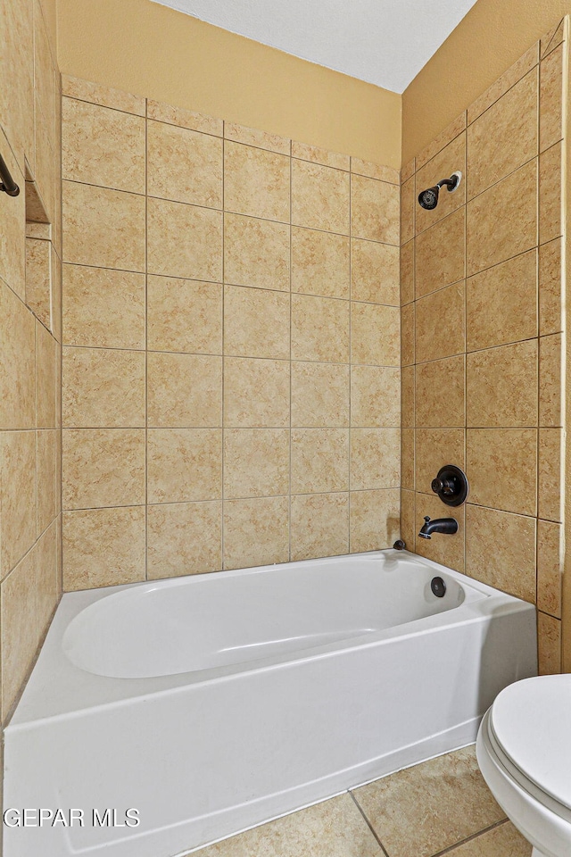 bathroom featuring tile patterned floors, toilet, and washtub / shower combination
