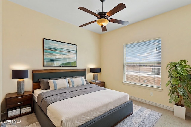 carpeted bedroom featuring baseboards and ceiling fan