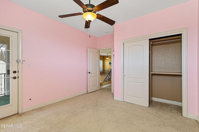 unfurnished bedroom featuring light colored carpet, baseboards, and a ceiling fan