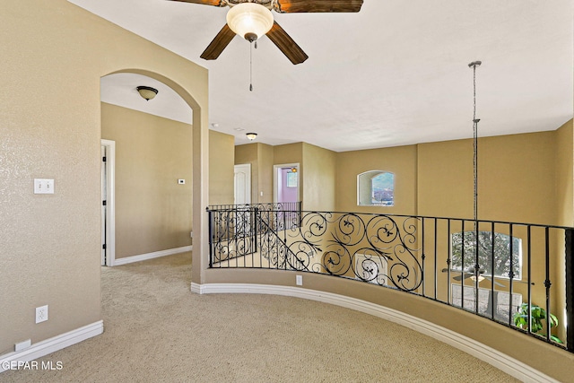 hallway with baseboards, an upstairs landing, and carpet