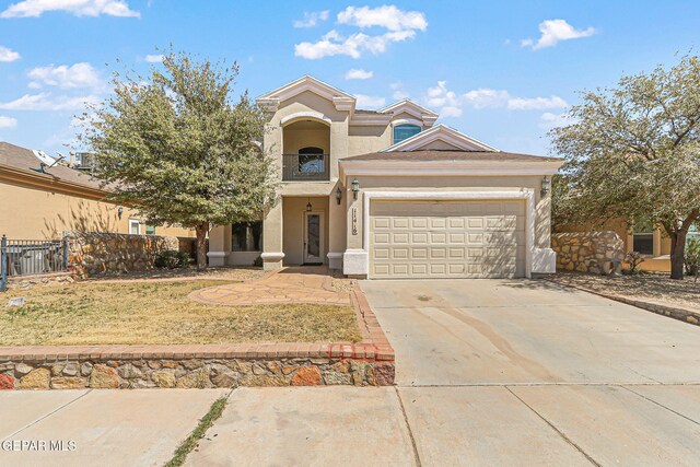 view of front of house with driveway, stucco siding, an attached garage, and fence