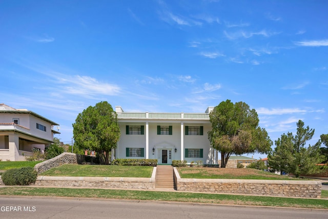 greek revival house featuring a front yard and stucco siding