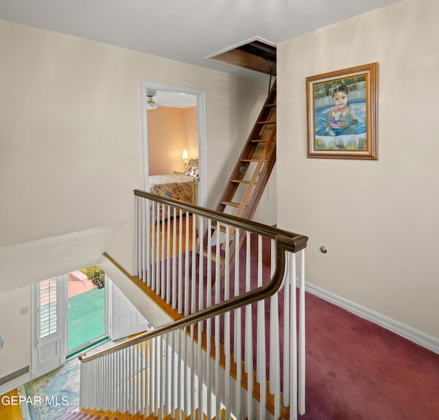 staircase featuring carpet floors and baseboards