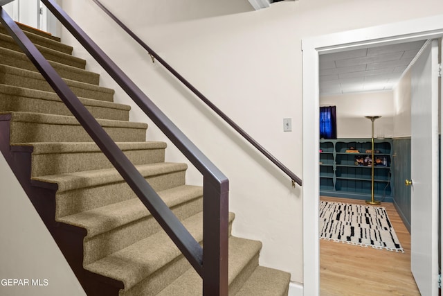 stairs featuring wood finished floors