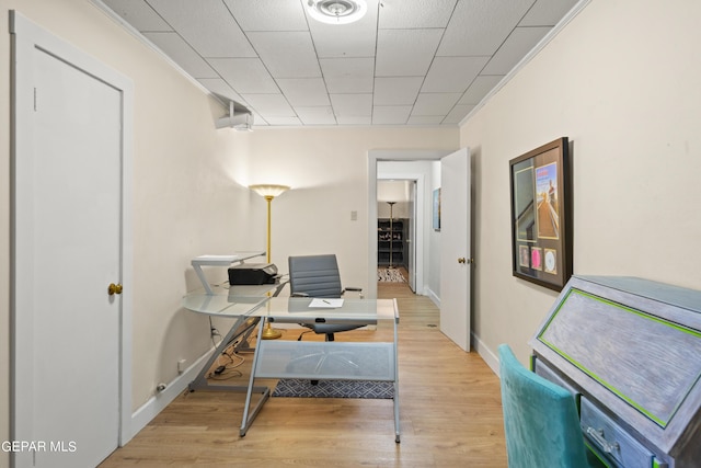 home office featuring light wood finished floors, baseboards, and crown molding