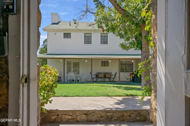 back of property featuring a lawn and a patio area