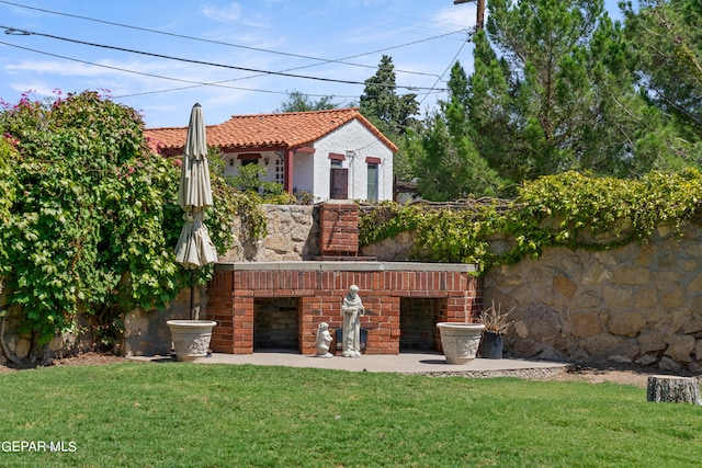 view of yard with an outdoor brick fireplace