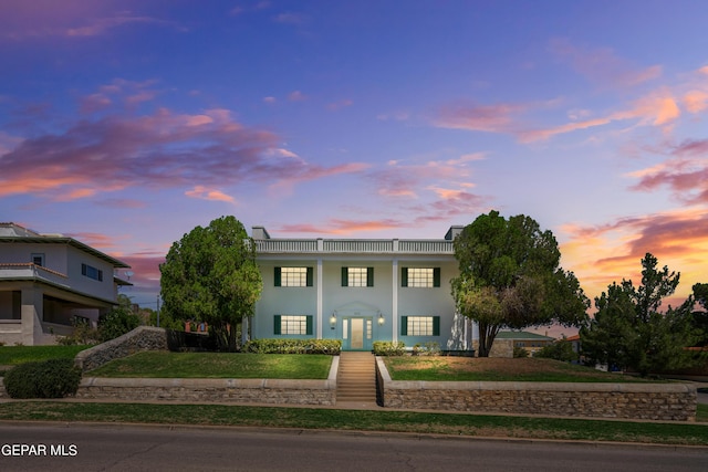 greek revival house with stucco siding and a front lawn