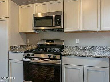 8718 Lawson St Unit 9, El Paso, TX 79904 - kitchen featuring white cabinetry, light stone countertops, and stainless steel appliances