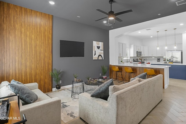 living room with recessed lighting, baseboards, arched walkways, ceiling fan, and visible vents