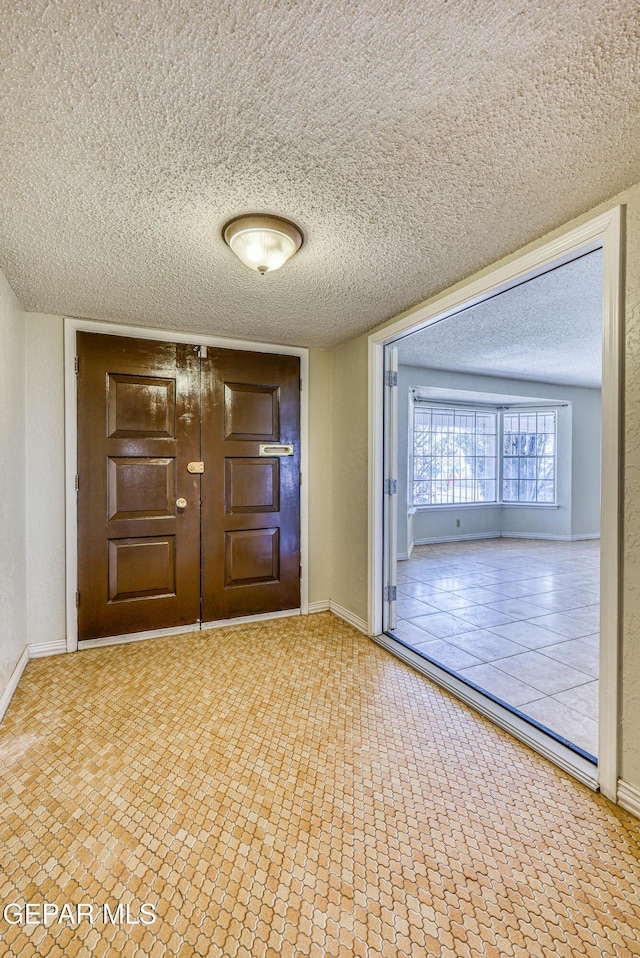 interior space with baseboards and a textured ceiling