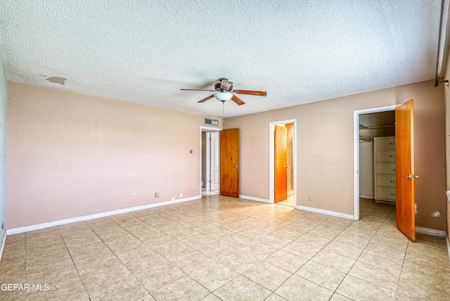 unfurnished bedroom featuring light tile patterned floors, visible vents, a textured ceiling, and a spacious closet
