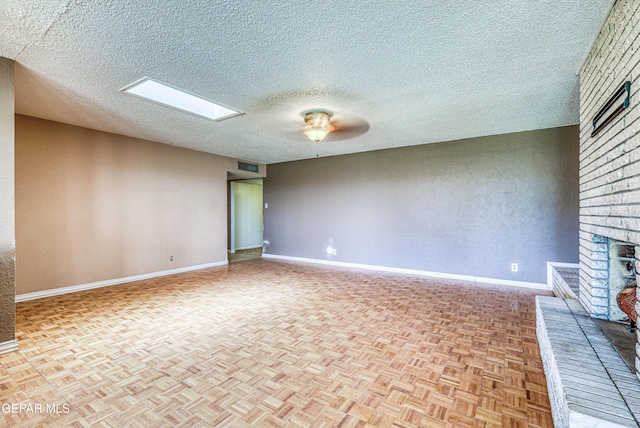 unfurnished living room featuring baseboards, a brick fireplace, a textured ceiling, and visible vents