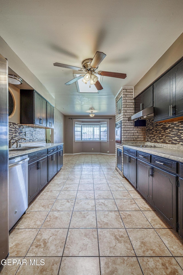 kitchen with light countertops, a sink, tasteful backsplash, and stainless steel appliances