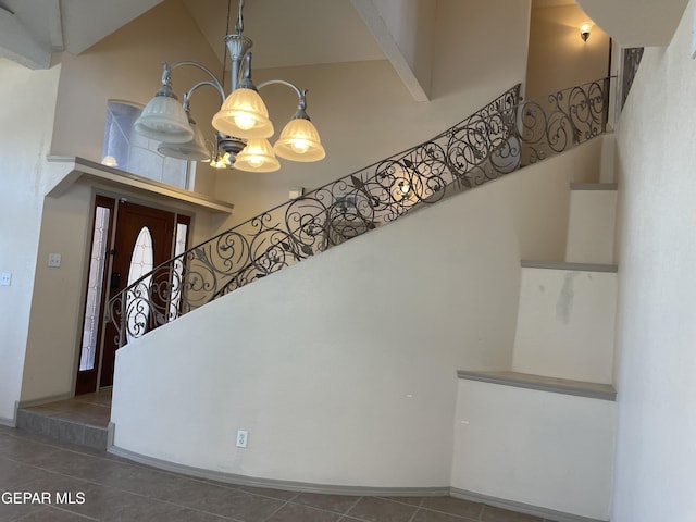 entrance foyer with tile patterned flooring, baseboards, a high ceiling, and stairway