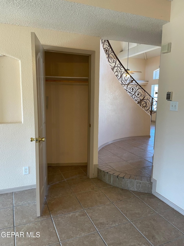 interior space with visible vents, a textured ceiling, baseboards, and tile patterned flooring